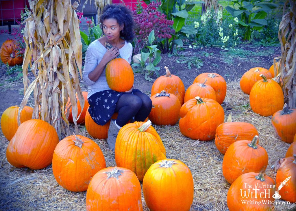 woman holding a pumpkin in a pumpkin patch